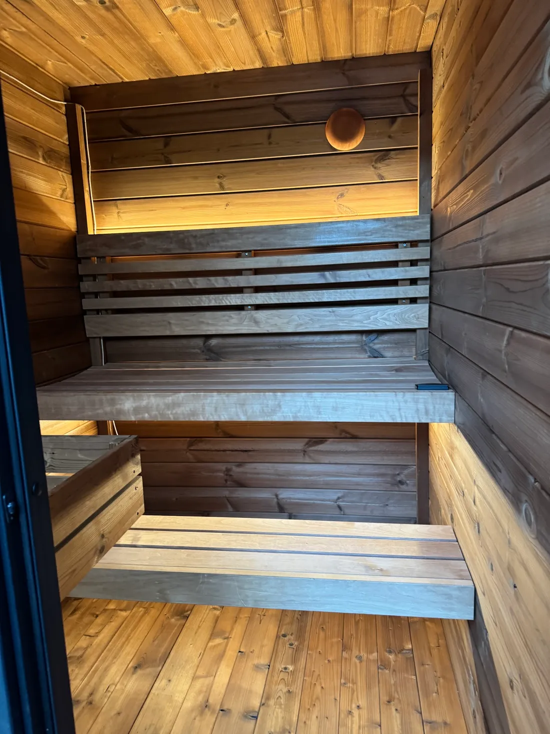 Lit benches and backrest inside a cedar sauna, Foster City