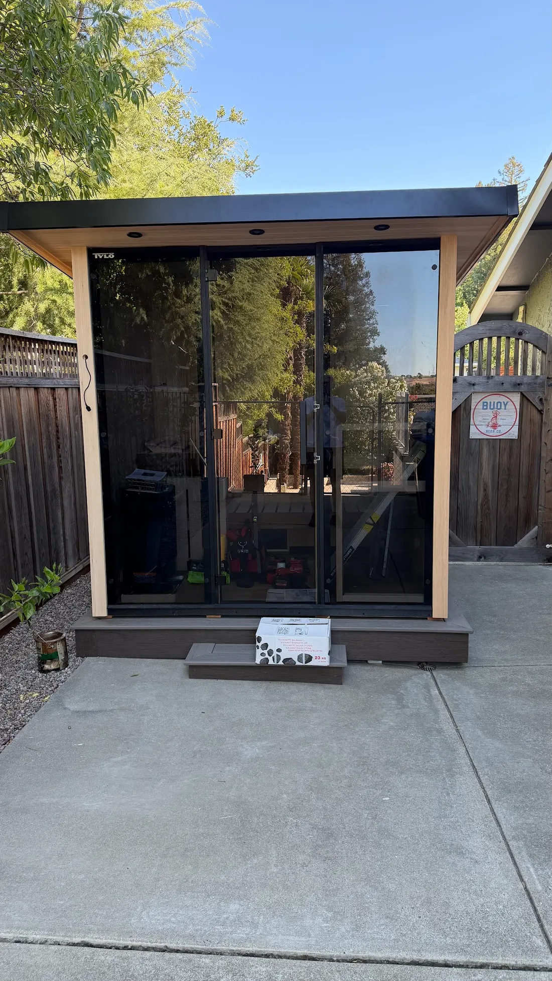 An outdoor sauna with glass doors on a concrete pad, San Jose
