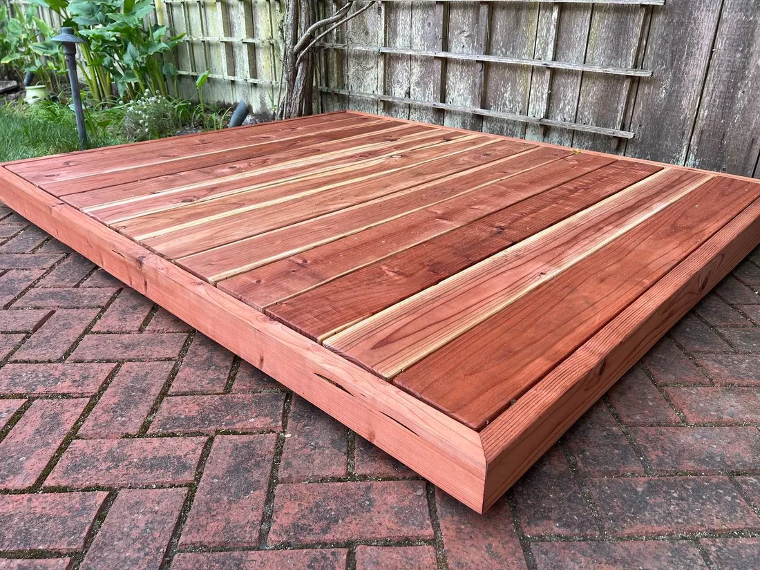 A redwood platform built on a brick patio, ready for a sauna