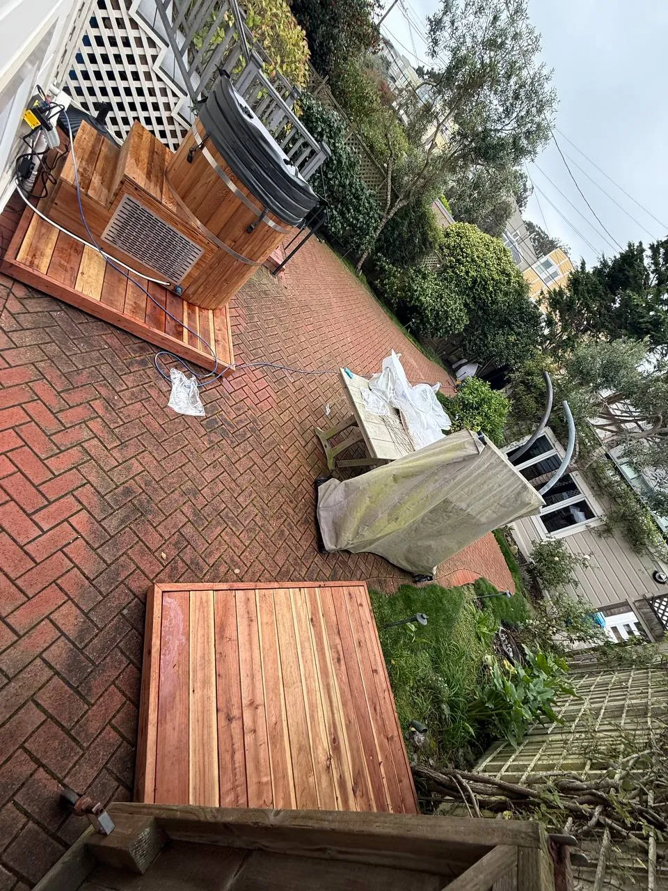 Redwood parts laid out on a brick patio during an outdoor build
