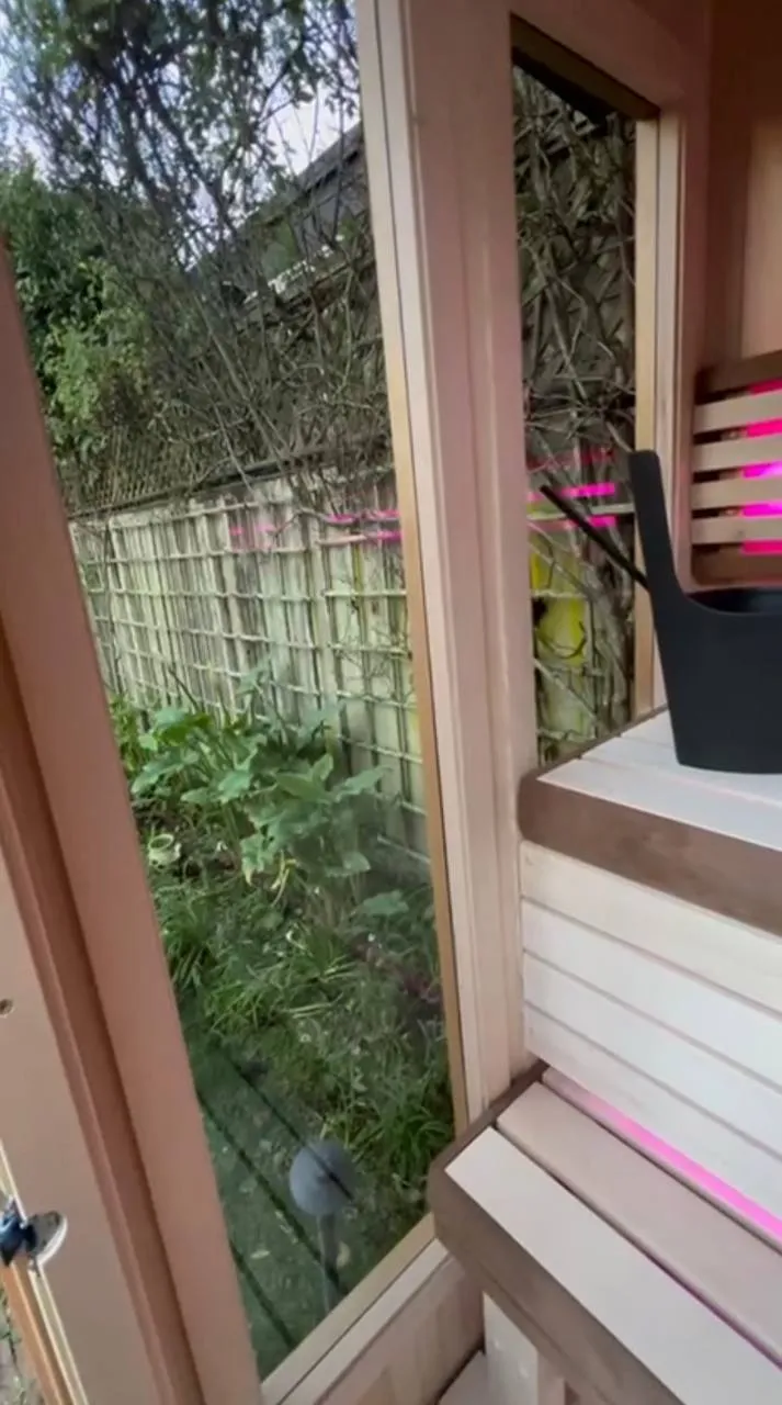 The doorway of an outdoor sauna with the garden beyond