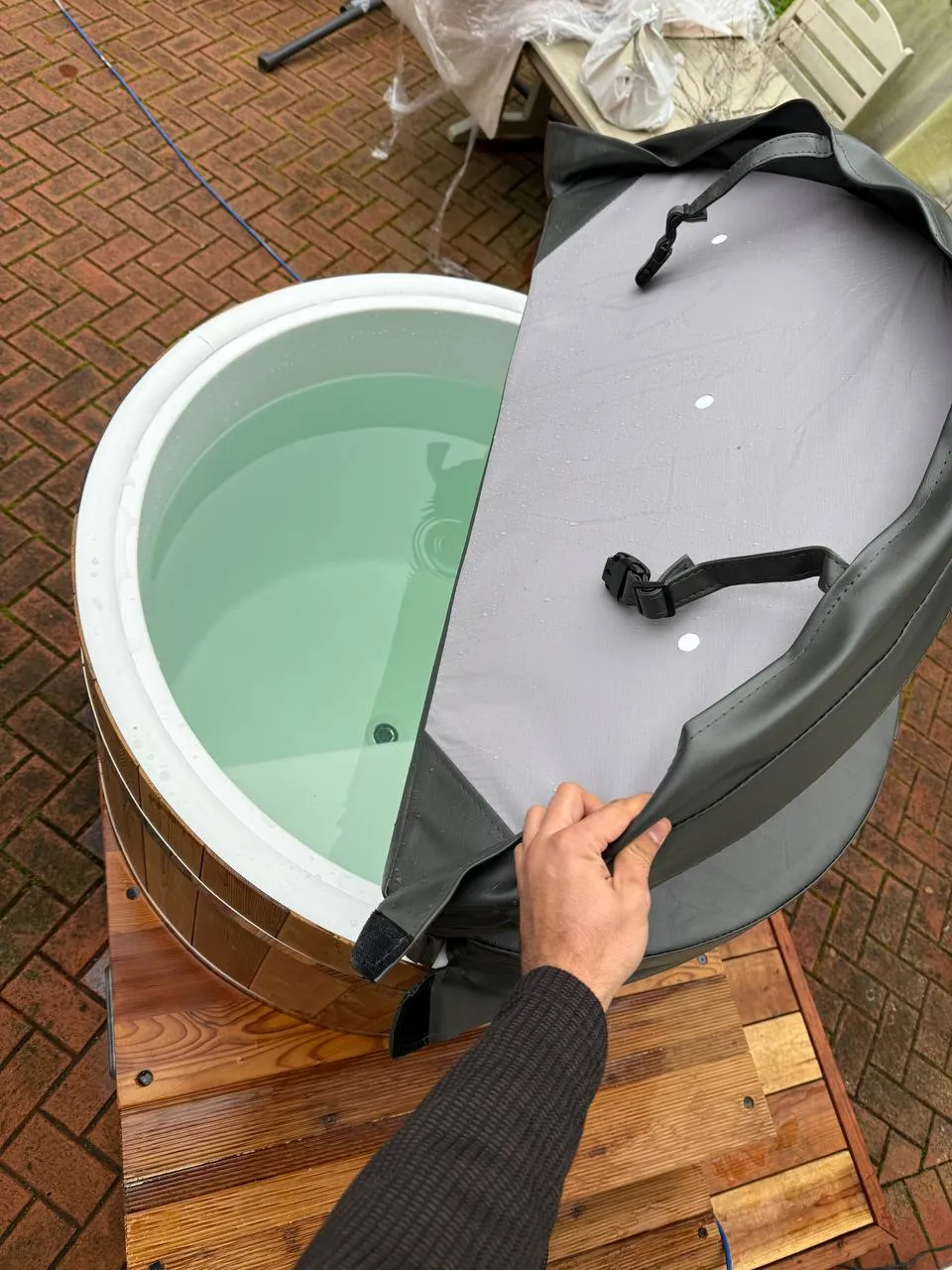 A cold plunge tub being set up on a wooden platform